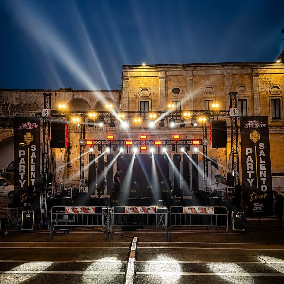 A stage lit at night in front of a historic building