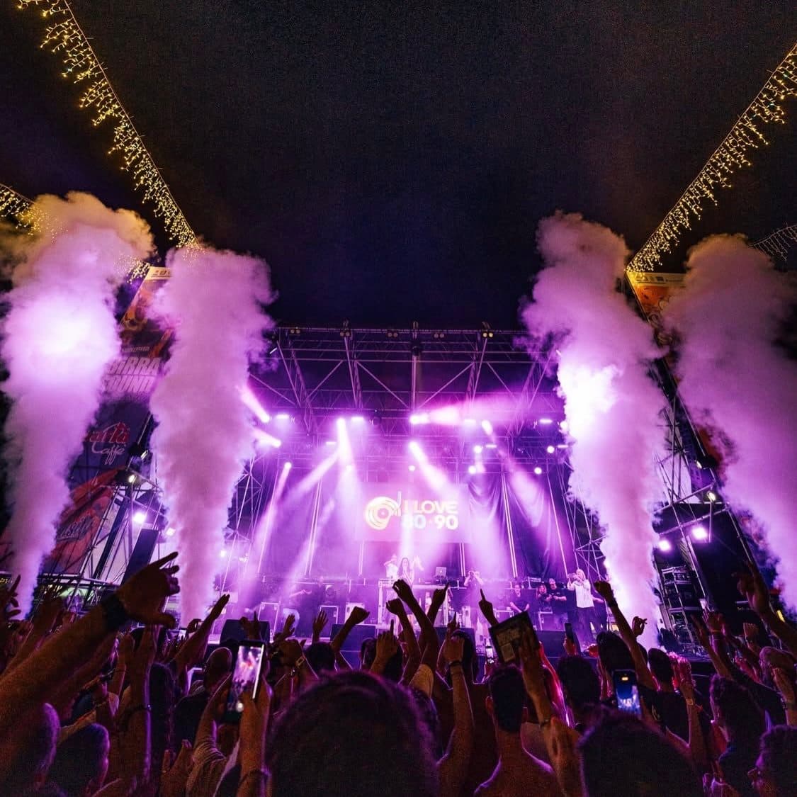 A purple stage in haze with CO2 jets and a crowd