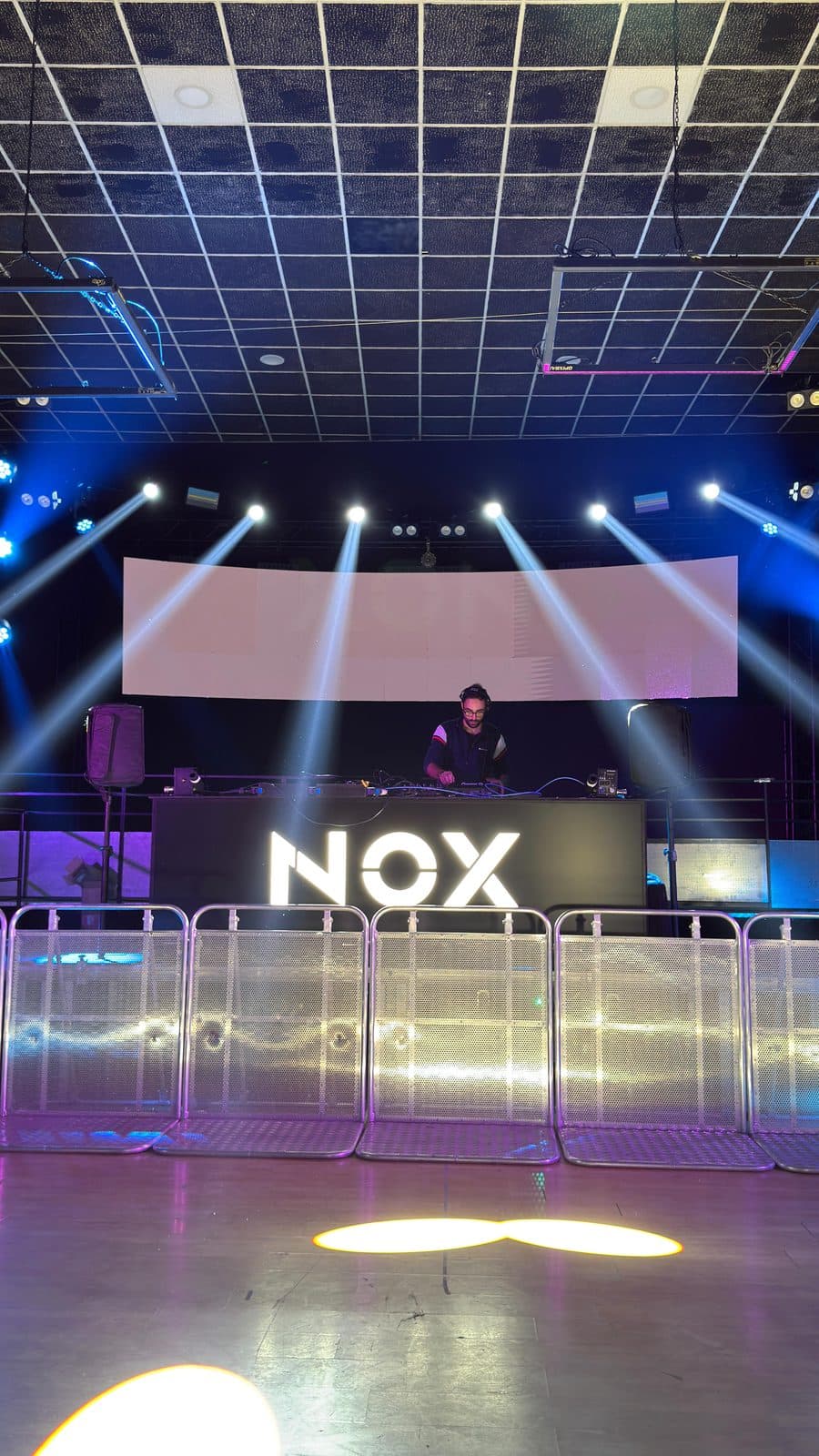 A DJ at the booth with lighting and LED wall indoors