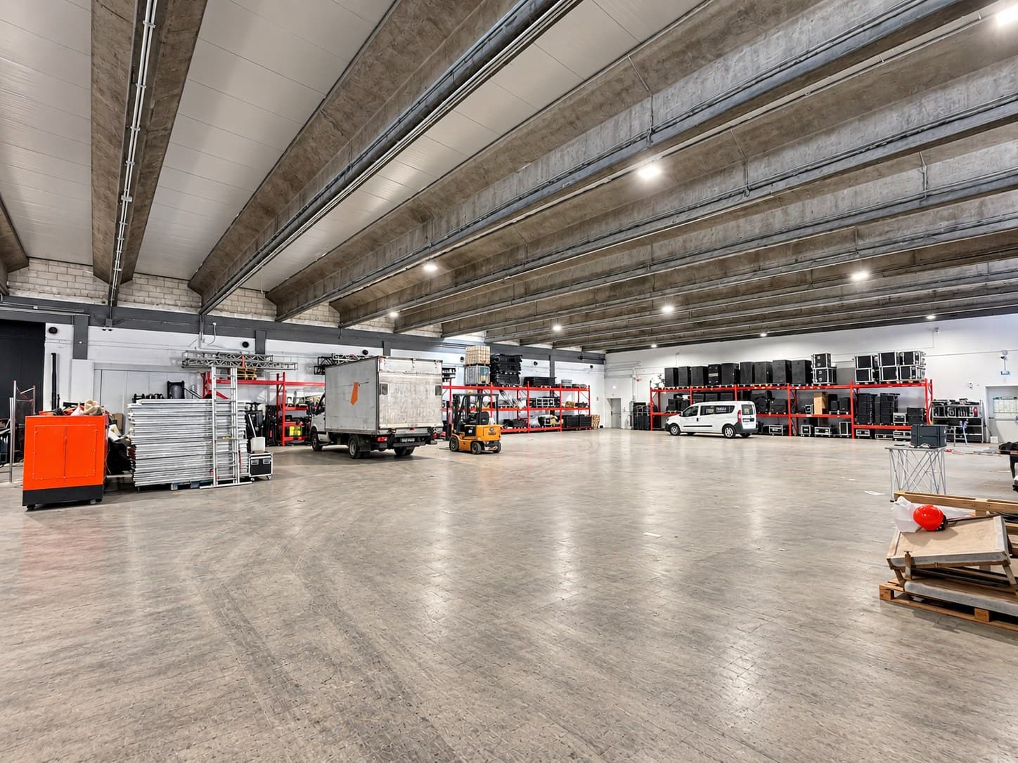 The warehouse seen end to end, vans and racking along the far wall