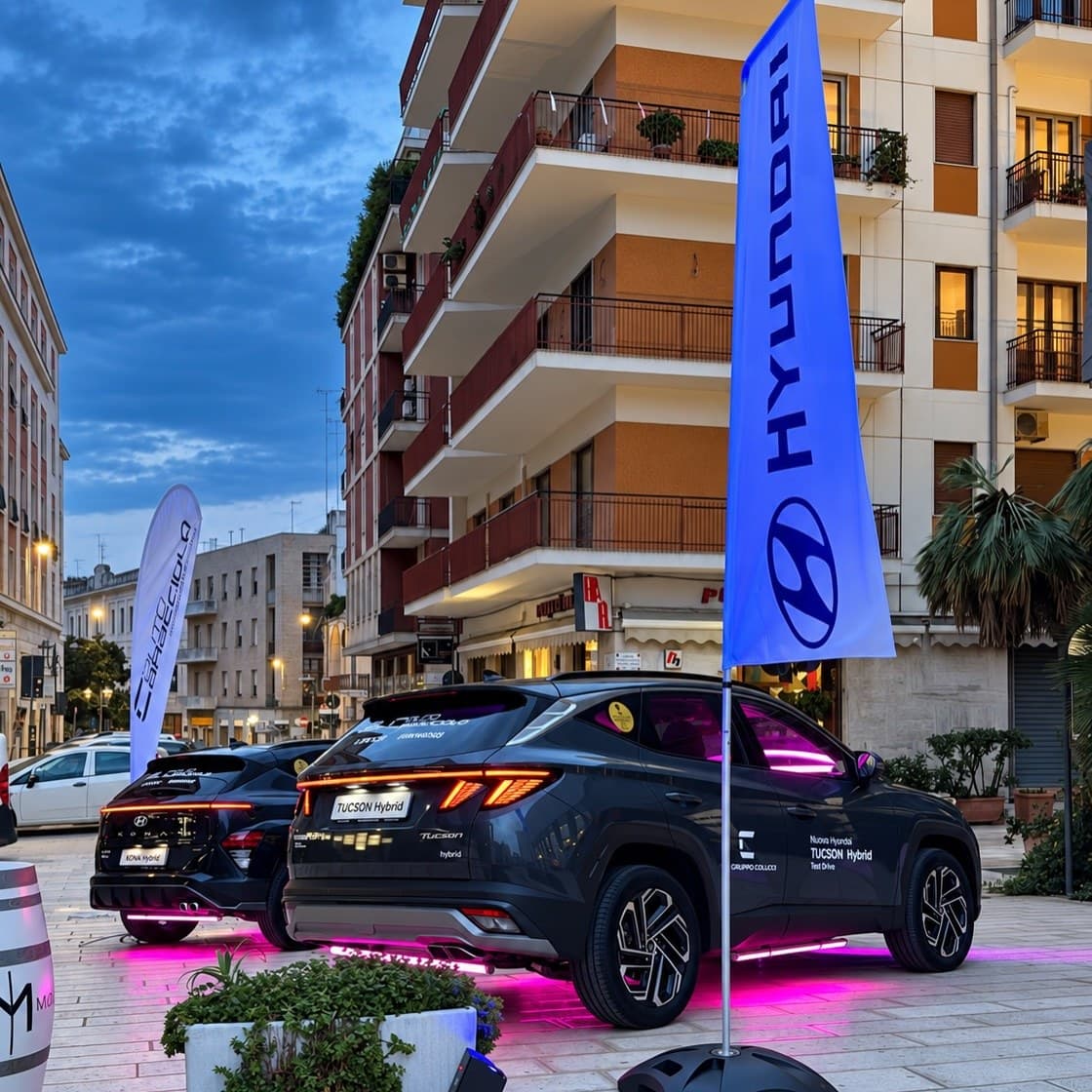 The same launch seen from the side, flags and lit cars between the buildings